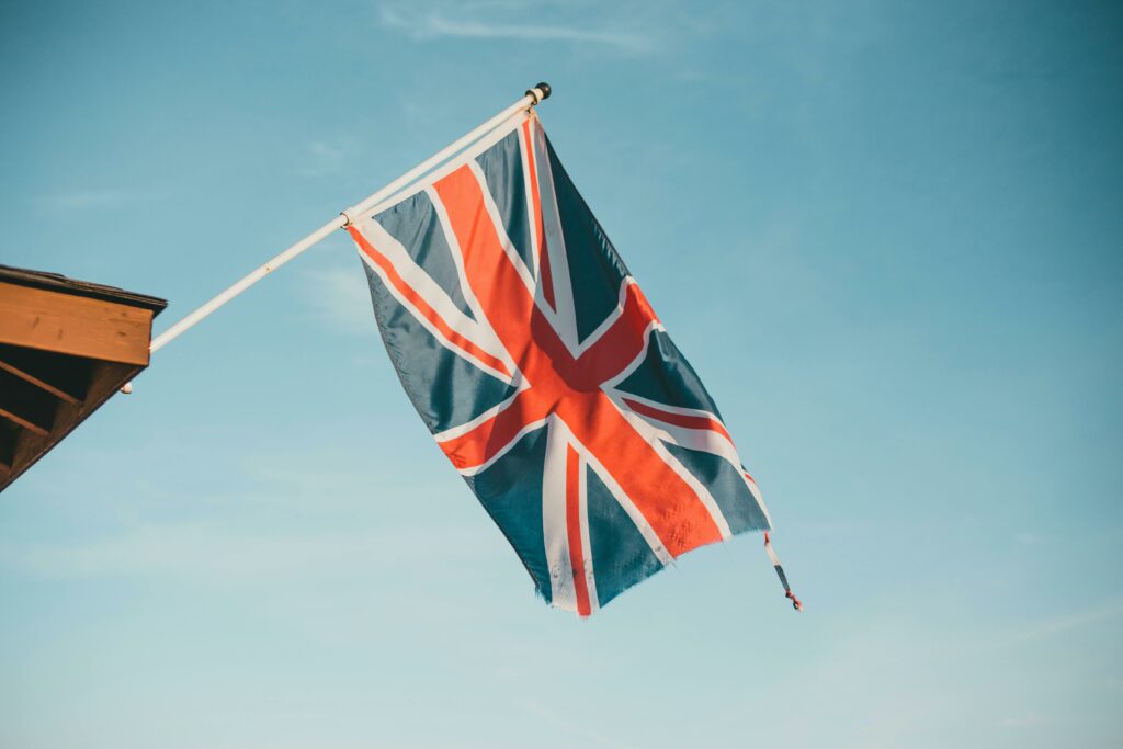 Union Jack flap in the breeze against a clear blue sky, symbolizing British pride.